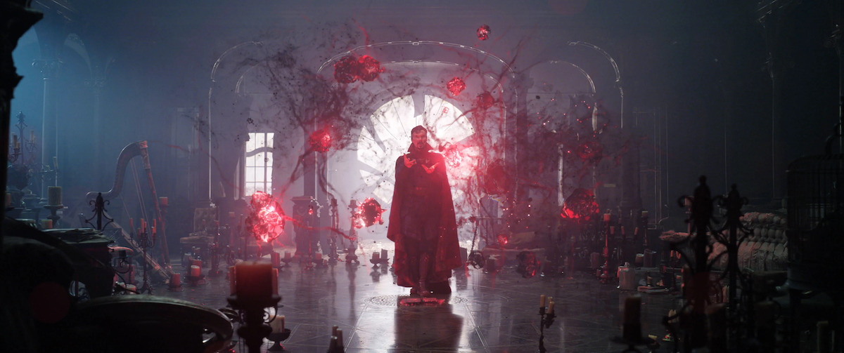 Benedict Cumberbatch in "Doctor Strange" standing in a large room surrounded by glowing read lights connected to each other by thin membranes