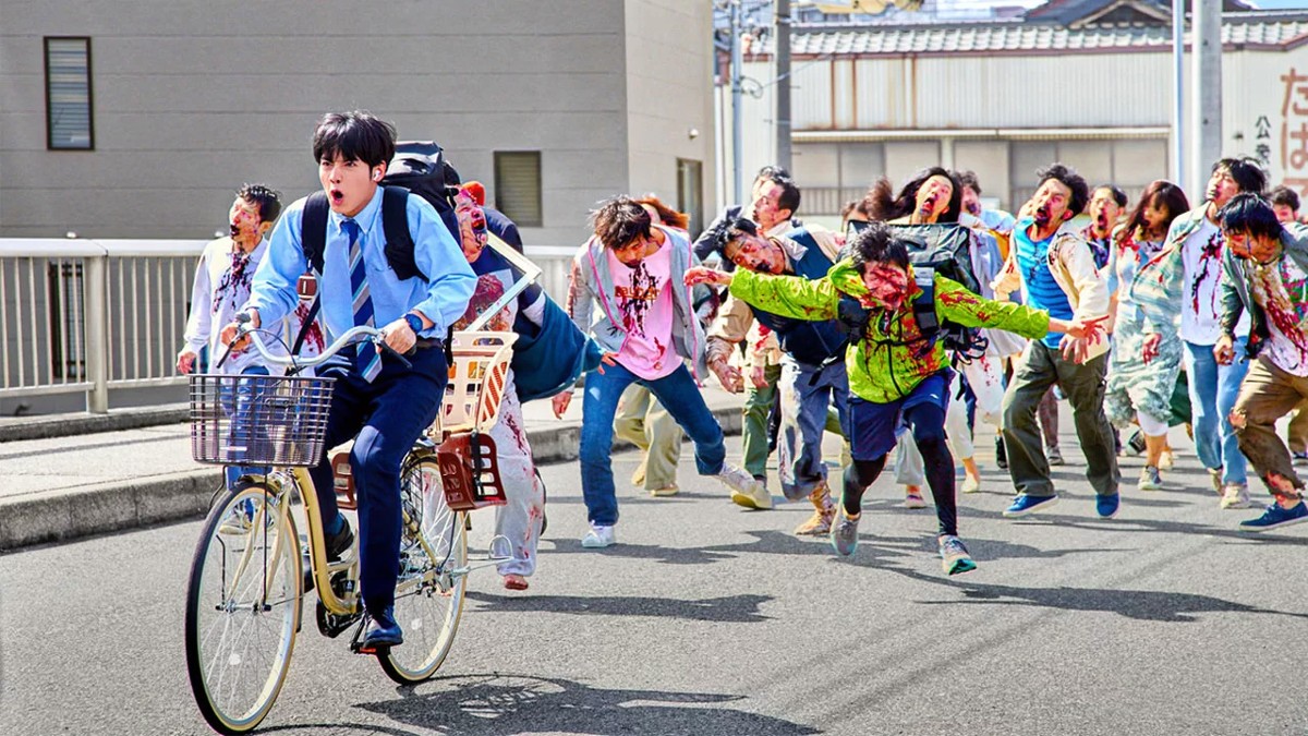 Eiji Akaso as Akira Tendo being chased by zombies in Zom 100: Bucket List of the Dead
