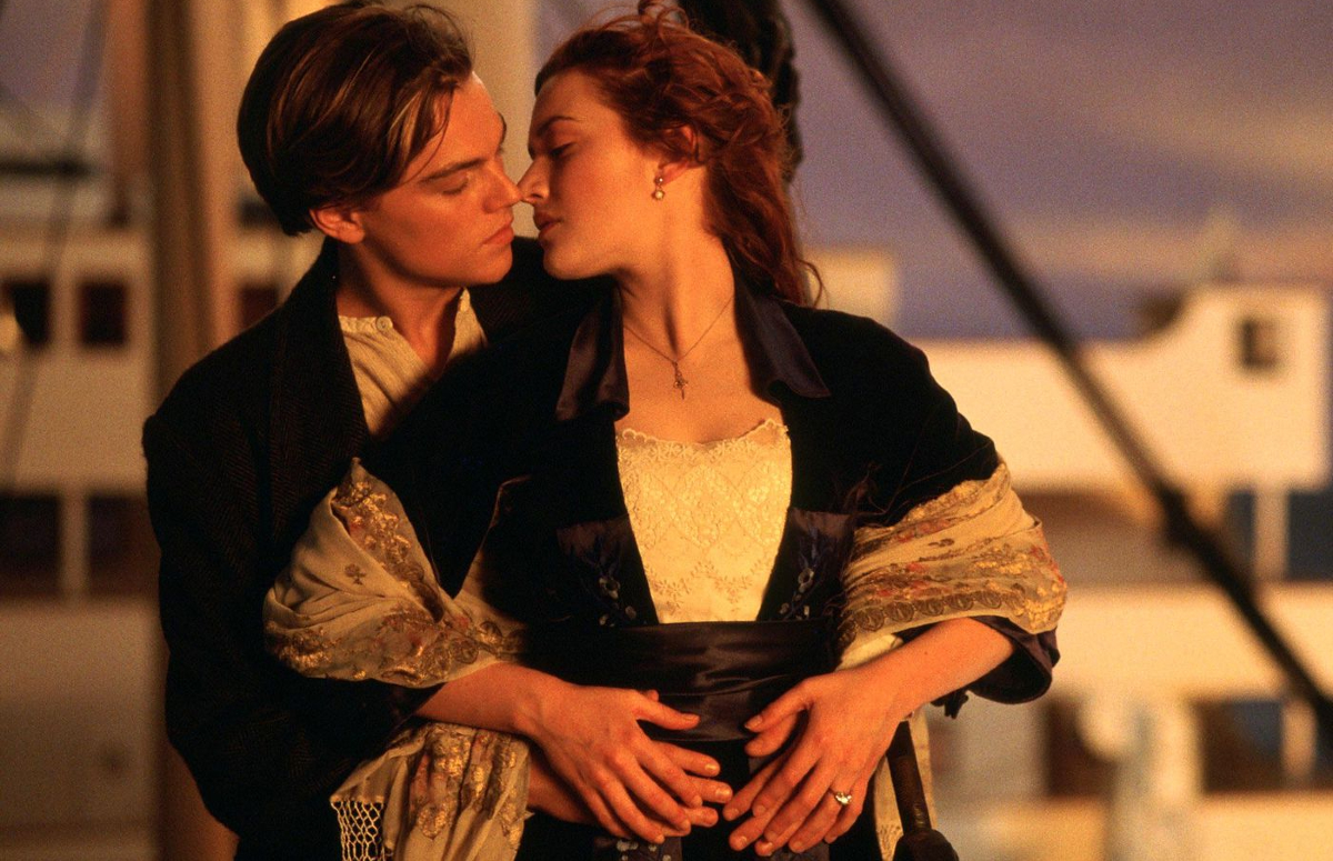 Leonardo DiCaprio and Kate Winslet hold each other and nearly share a kiss in "Titanic"