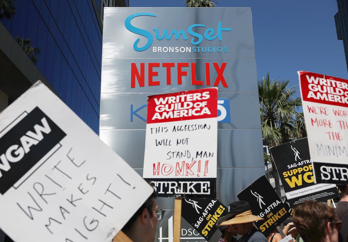 Writers Guild and SAG AFTRA members on a picket line protesting Netflix's refusal to pay fair wages and safeguard against AI