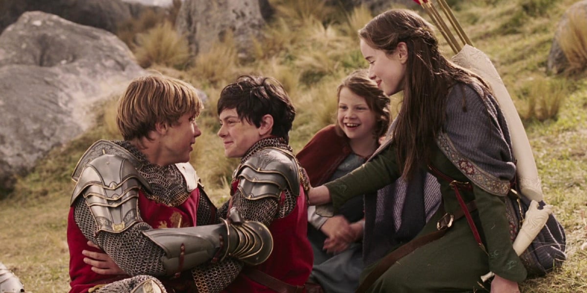 The Pevensie siblings hugging each other in The Lion, the Witch and the Wardrobe. From left to right: William Moseley as Peter Pevensie, Skandar Keynes as Edmund Pevensie, Georgie Henley as Lucie Pevensie, and Anna Popplewell as Susan Pevensie