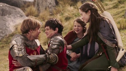 The Pevensie siblings hugging each other in The Lion, the Witch and the Wardrobe. From left to right: William Moseley as Peter Pevensie, Skandar Keynes as Edmund Pevensie, Georgie Henley as Lucie Pevensie, and Anna Popplewell as Susan Pevensie