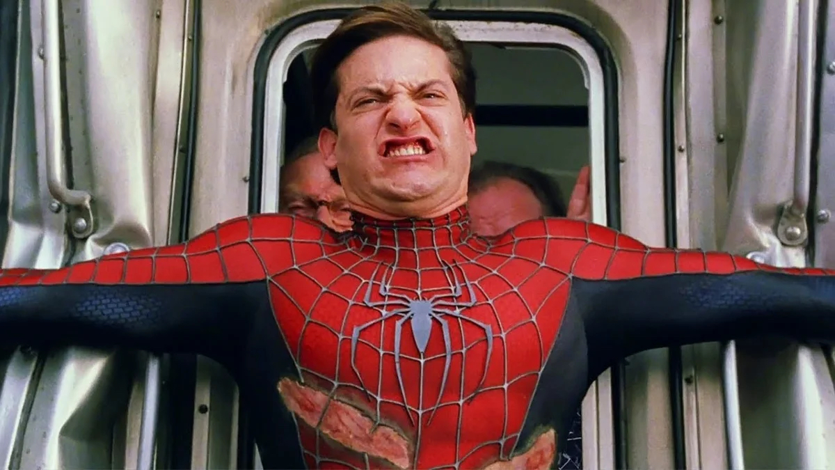 Spider-Man straining to hold back a subway train from crashing while terrified passengers look on in "Spider-Man 2"