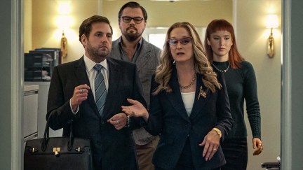 Two scientists trail after the president and her assistant in 