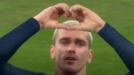 A male soccer player making a heart gesture with his hands.