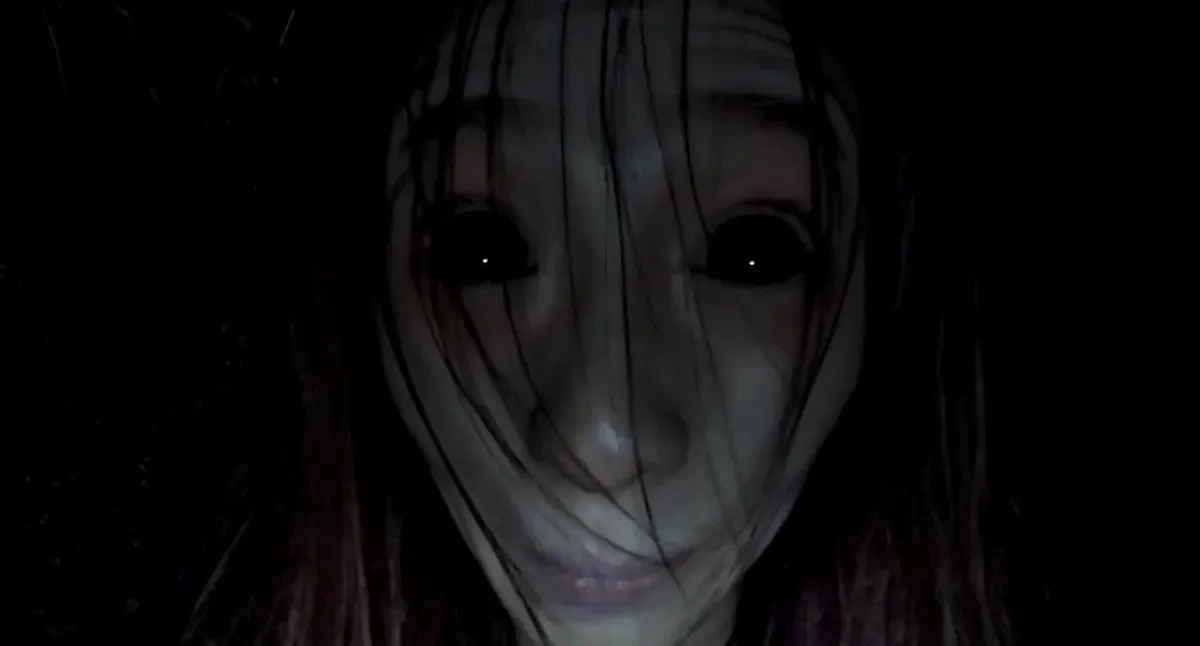 A black eyed ghost woman stares into the camera in "Gonjiam: Haunted Asylum"