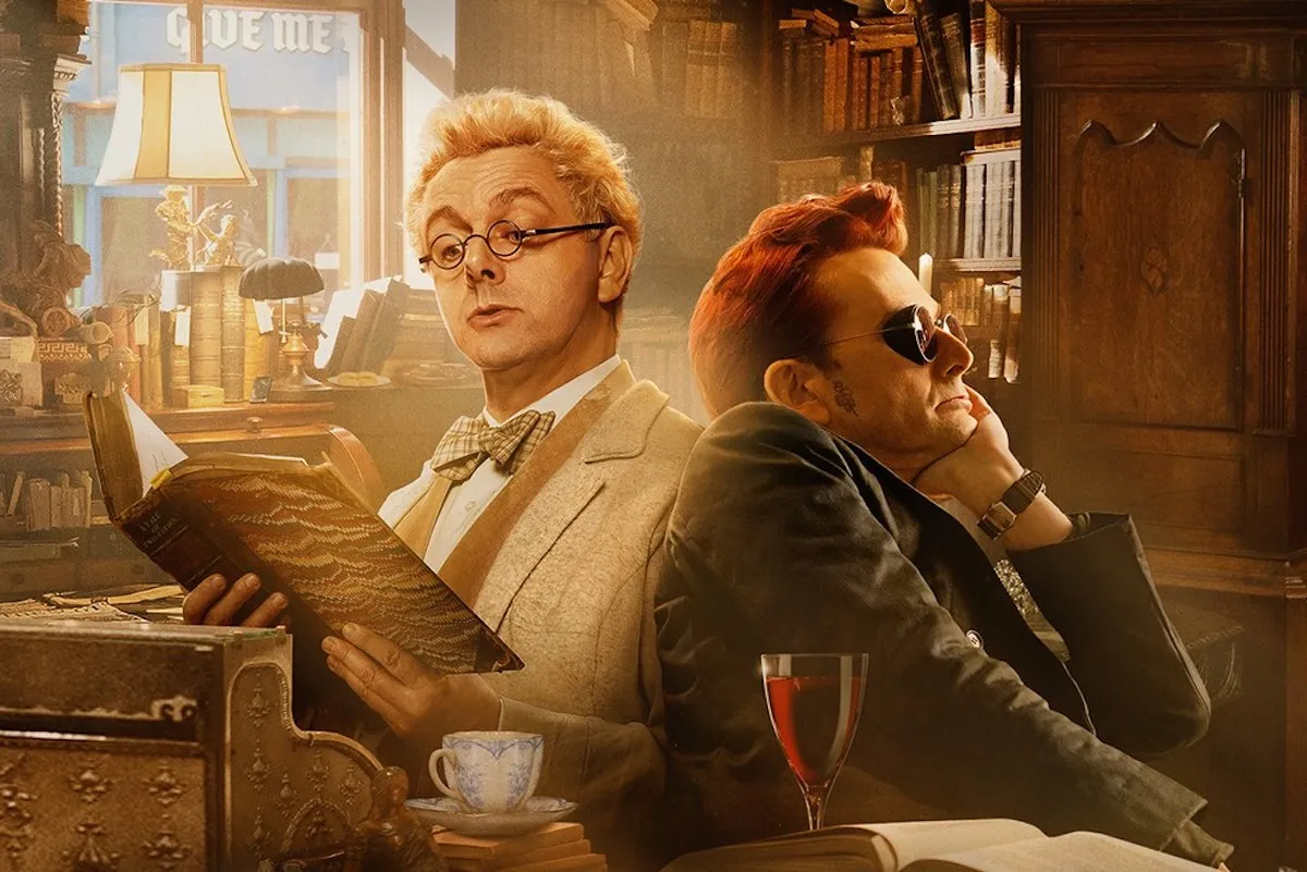 Aziraphale and Crowley sit back to back in Aziraphale's bookshop. Aziraphale is reading a book while Crowley stares into the distance.