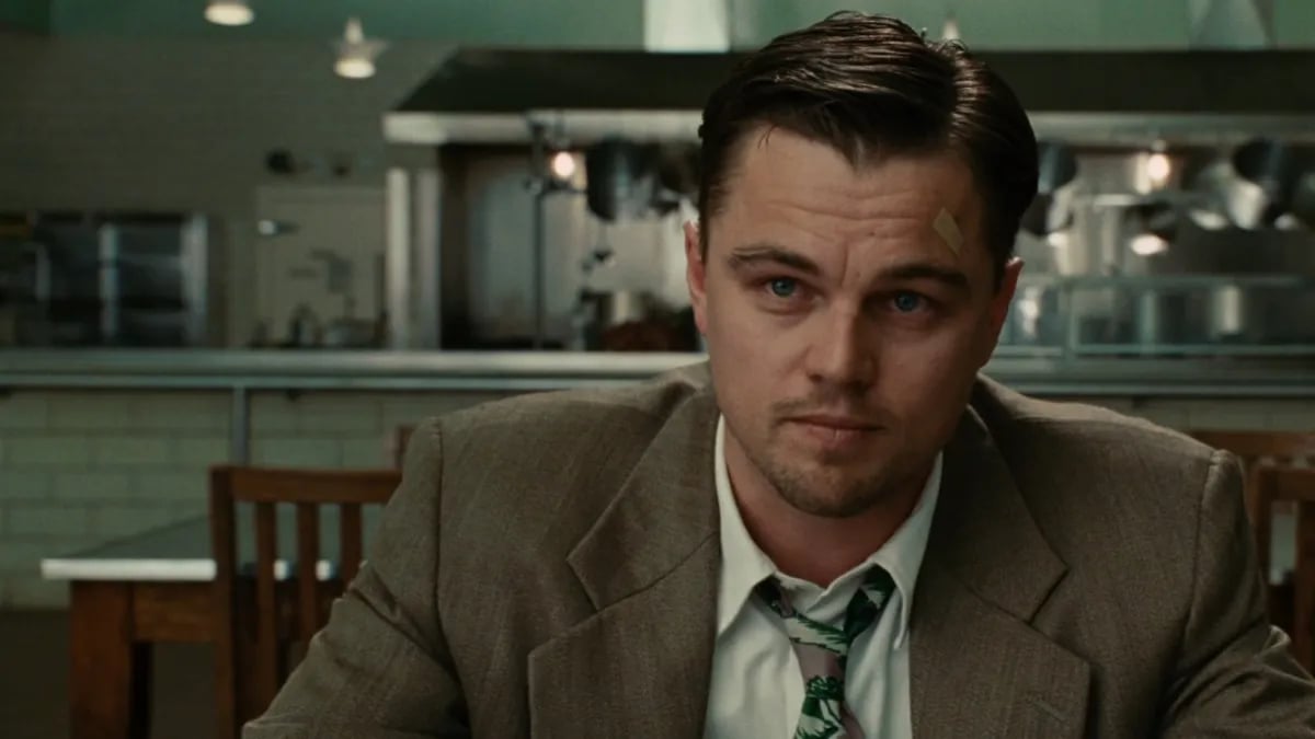 Teddy Daniels in a suit and tie sits and looks intensely at something offscreen in "Shutter Island"