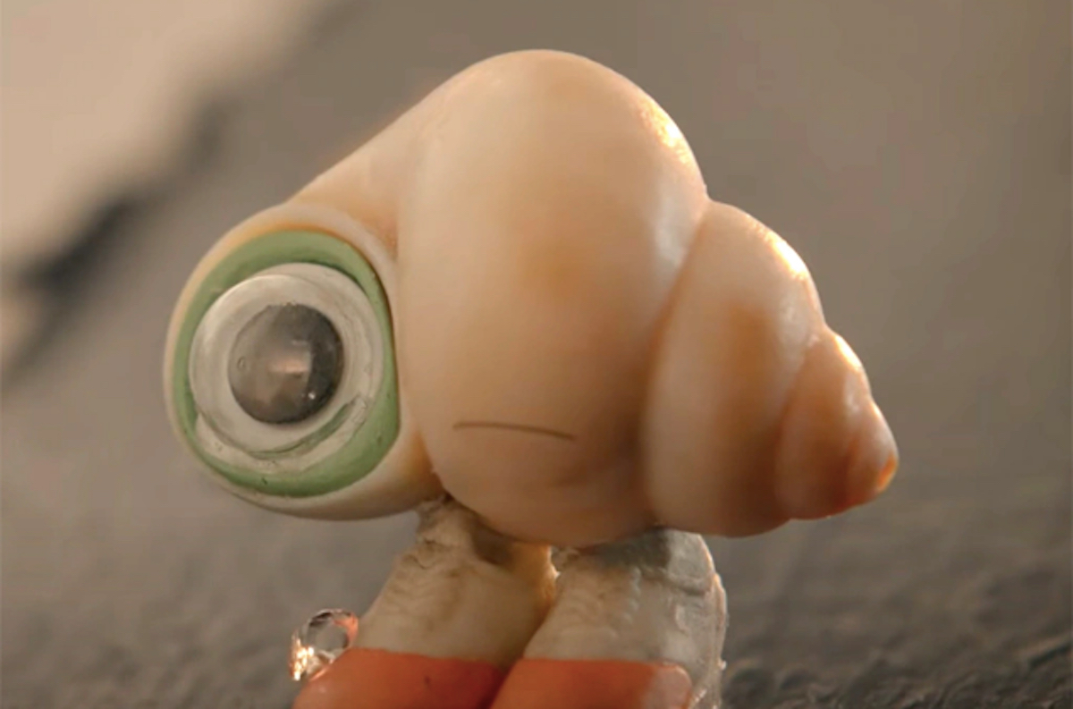 Marcel the Shell, a goofy little shell with a googly eye and shoes standing on the carpet in "Marcel the Shell"
