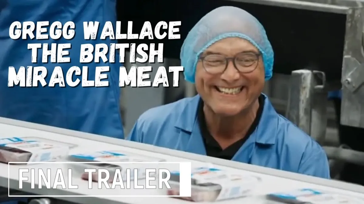 A man working on a meat assembly line and smiling at the camera.