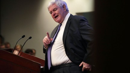 Newt Gingrich speaks pompously from a podium.