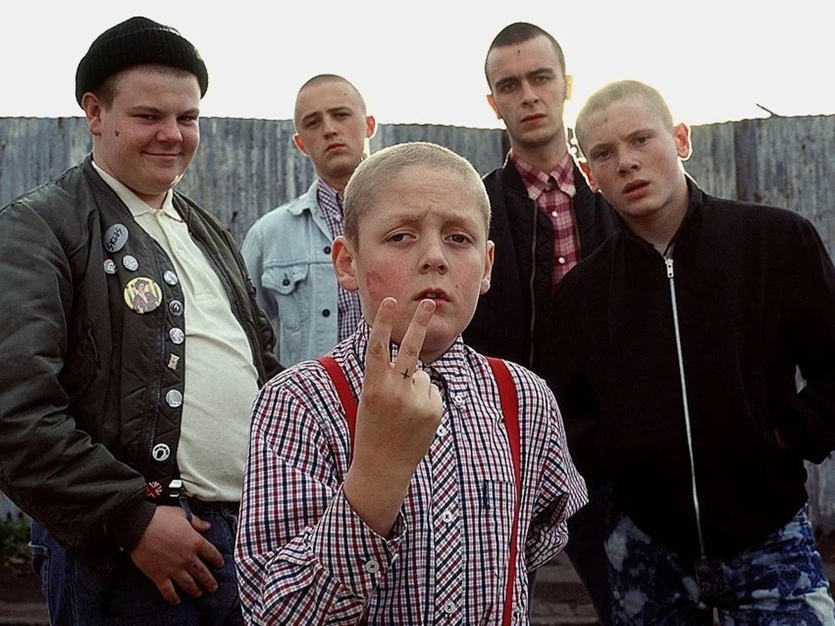 A group of young white boys with skinned haircuts huddle together in "This is England"