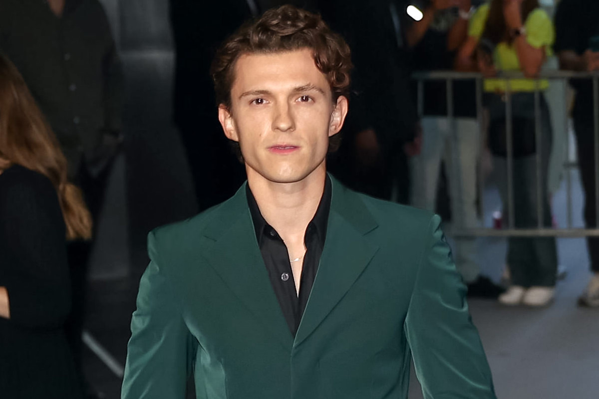 Tom Holland in a green suit at a movie premiere.