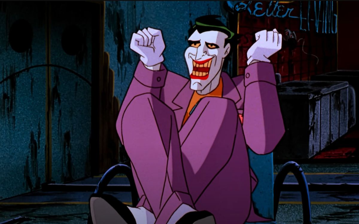 An animated Joke sits on the ground cross legged and laughing in "Batman: Mask of the Phantasm"