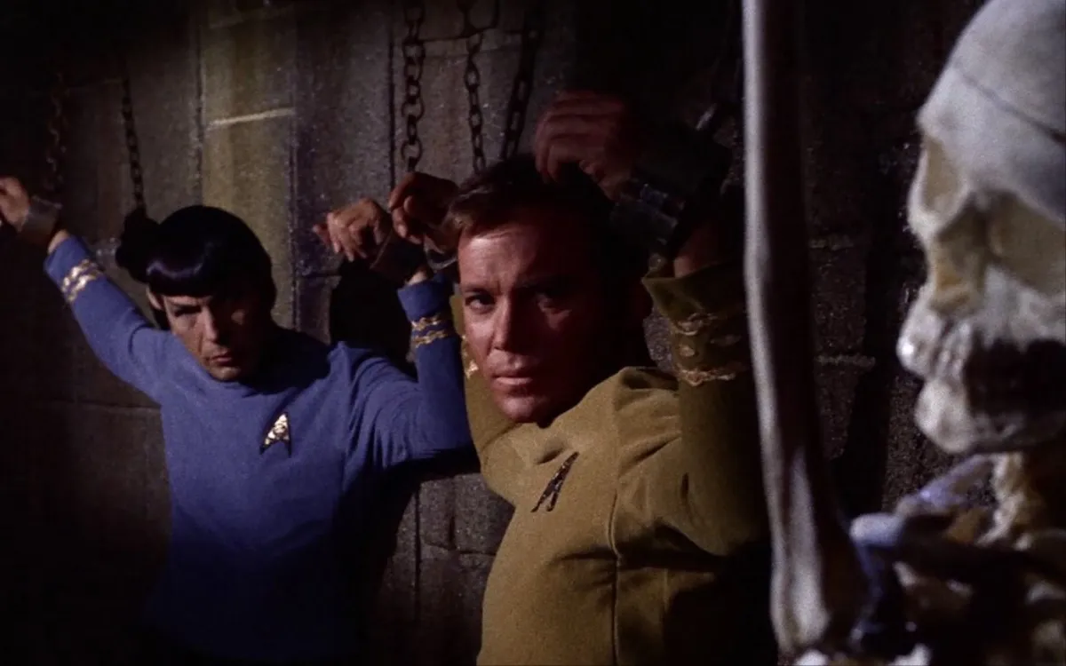 Spock and Kirk in shackles next to a skeleton in "Catspaw" in 'Star Trek: The Original Series' 