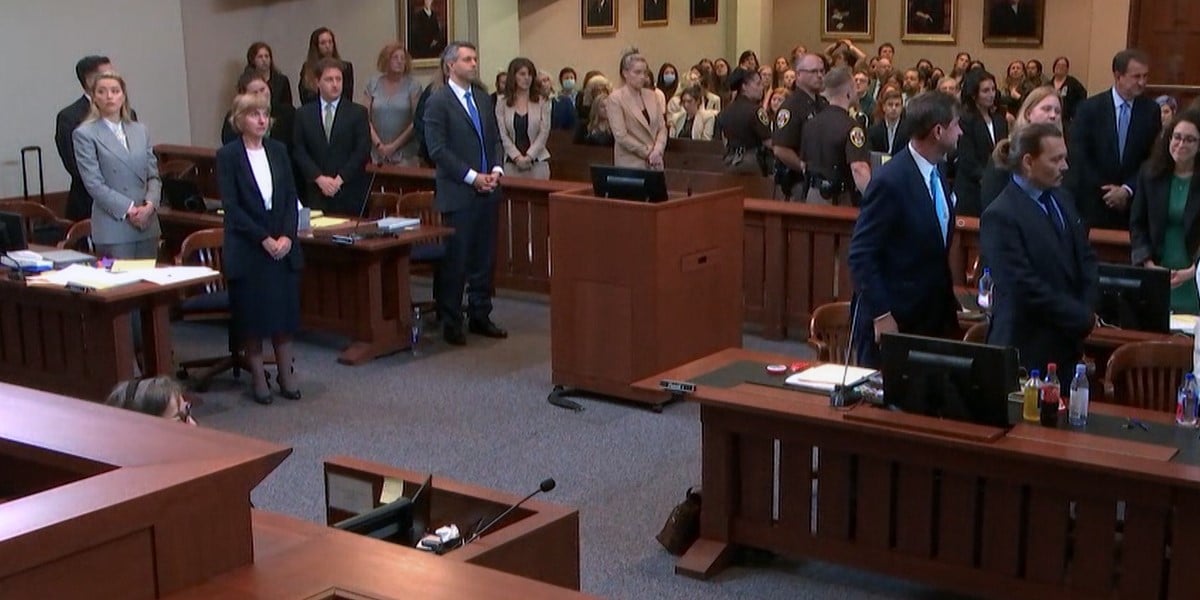 Netflix's 'Depp V Heard.' Everyone standing in the courtroom during the Depp V Heard trial. Johnny Depp and his legal team are on the right, Amber Heard and her legal team are on the left.