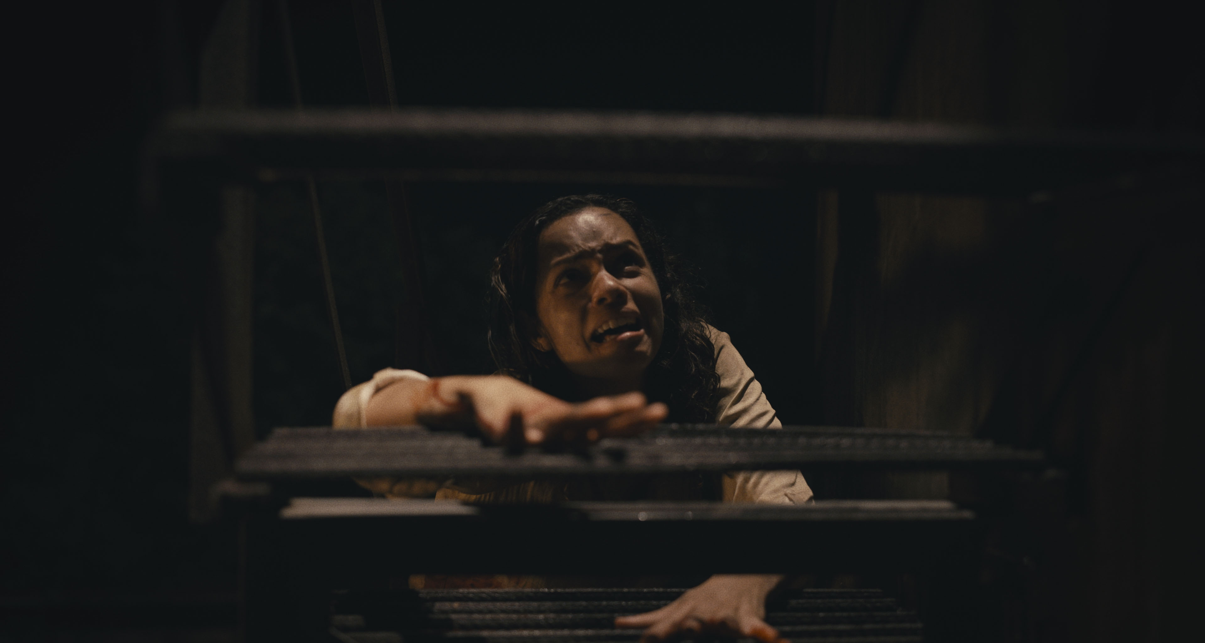 A distraught Tess (Georgina Campbell) crawls up basement steps in ‘Barbarian.’ 