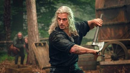 A long-haired man swings an axe during battle on 'The Witcher.'
