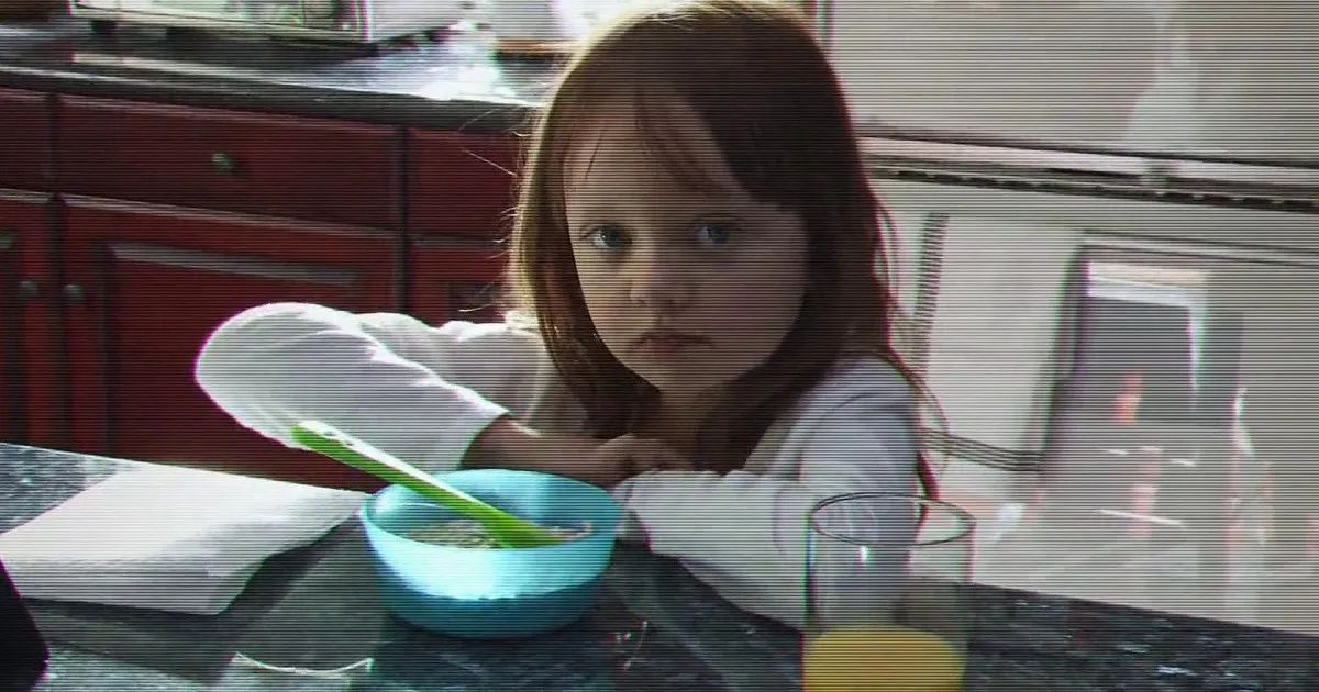 Leila Fleege (Ivy George) staring at the camera during breakfast