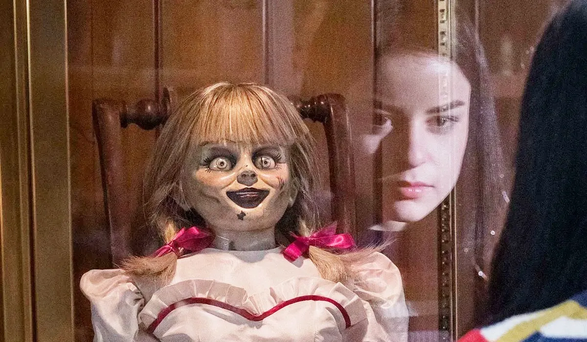 A small girl staring at Annabelle in "Annabelle Comes Home"