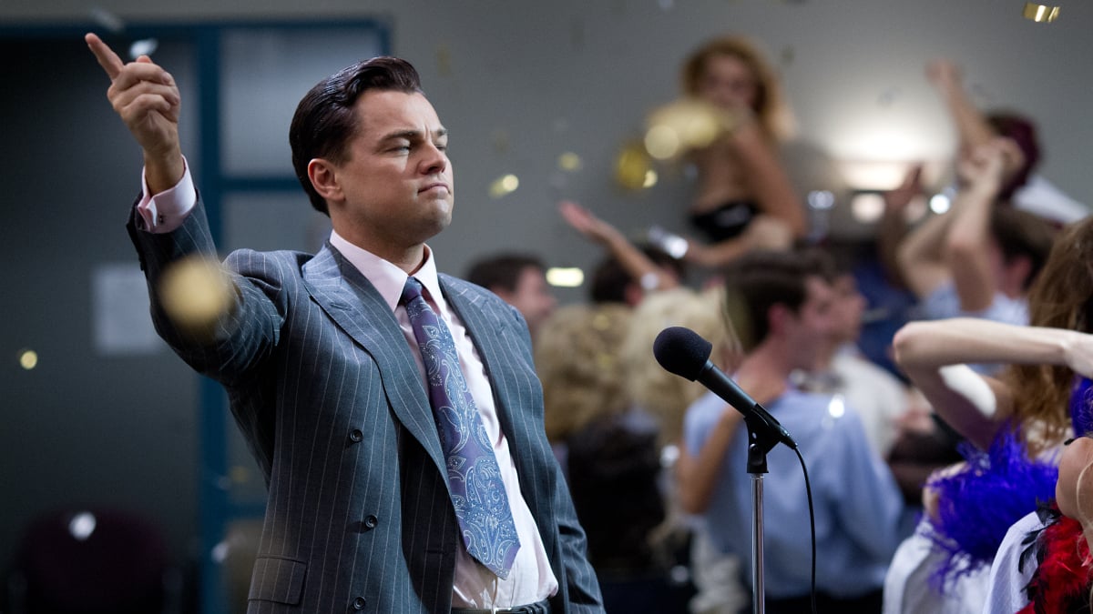 Leonardo DiCaprio as Jordan Belfort in 'The Wolf of Wall Street': A man looks triumphant as a crowd celebrates around him.