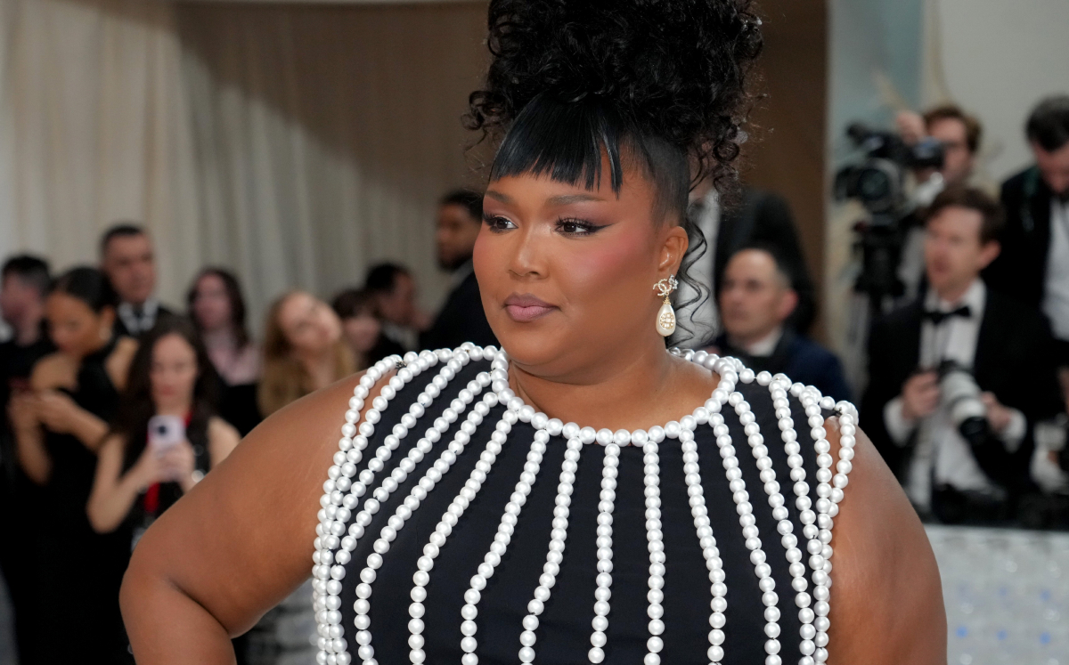 Lizzo wears a formal black dress with white beading while posing for photos at the 2023 Met Gala