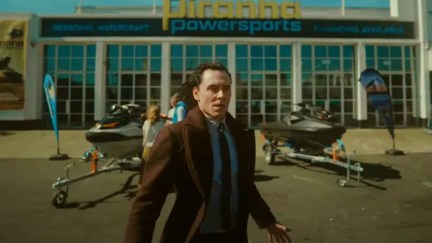 Loki looks around, disheveled, in front of a Jet ski dealership.