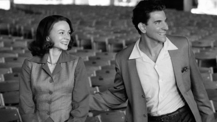 Bradley Cooper and Carey Mulligan stand together in an empty theater in a still image from Netflix's Maestro.