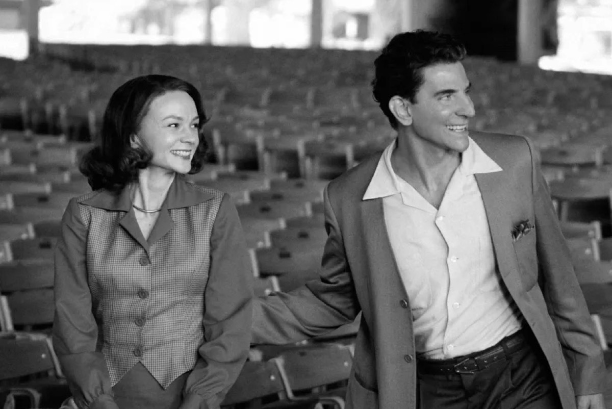 Bradley Cooper and Carey Mulligan stand together in an empty theater in a still image from Netflix's Maestro.