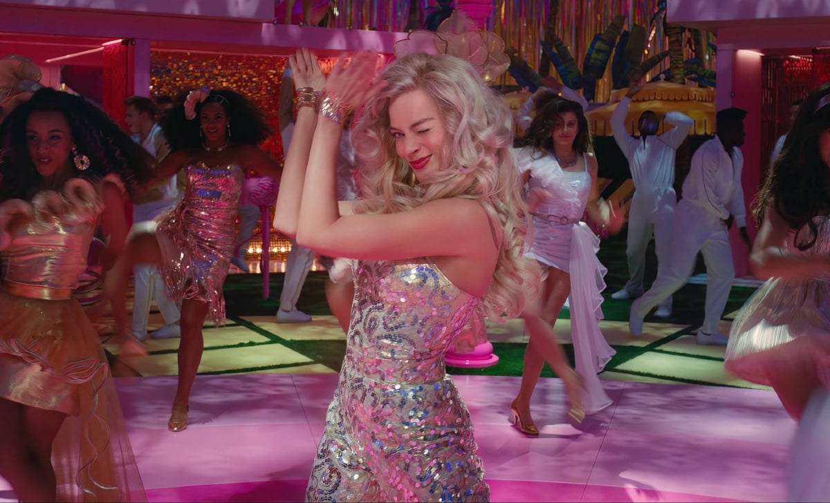 Barbie (Margot Robbie) dances with other Barbies during a vibrant dance party in 'Barbie'