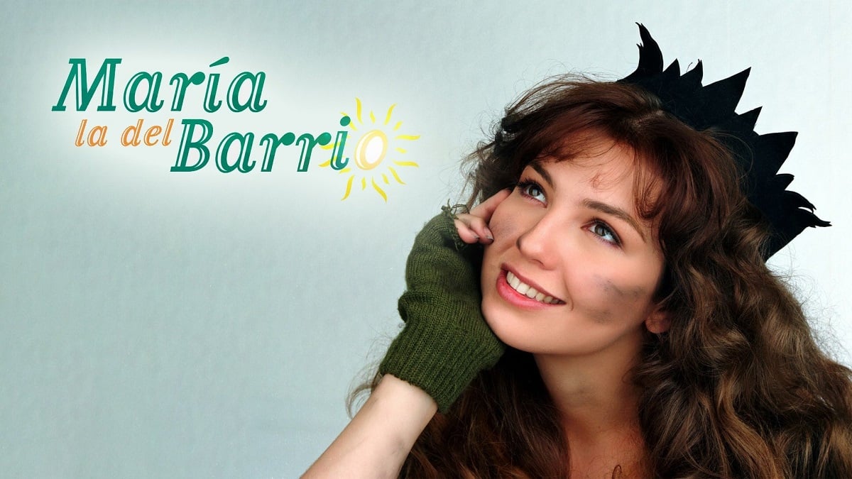 Promotional image for the telenovela 'Maria la del Barrio.' The left side of the image has the show's logo, and the right side of the image is Thalia in the role of Maria holding her chin in her hands and looking upward dreamily. She is a white Latina with long, wavy brown hair wearing a felt pointed crown on her head, and green fingerless gloves. Her face is smudged with dirt.