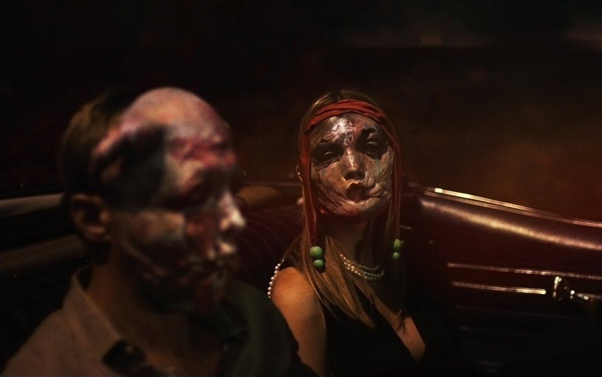 Alexander Skarsgård and Mia Goth don grotesque masks in ‘Infinity Pool.’ 