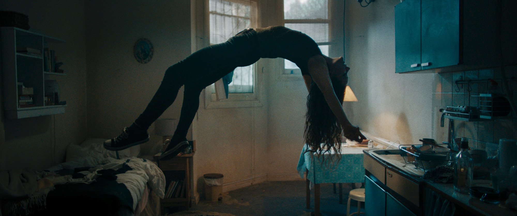 Maud (Morfydd Clark) levitates in her small apartment, in ‘Saint Maud.’