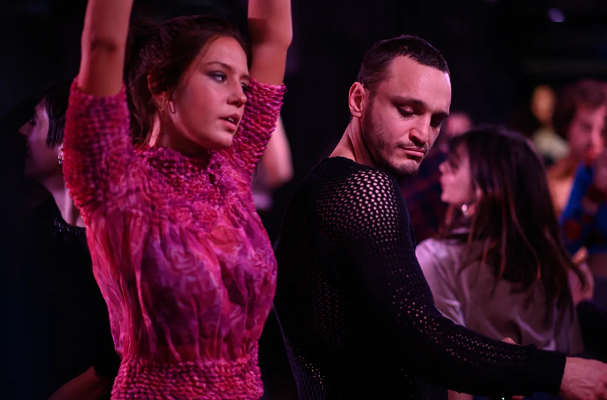 Agathe and Tomas dancing in pink hued lighting in the film "Passages"