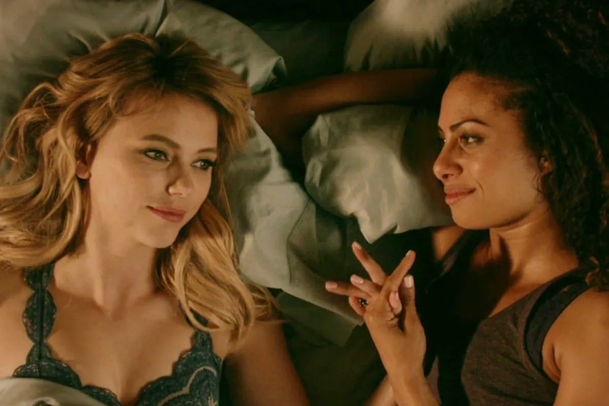A woman named Freya Mikaelson (Riley Voelkel) with her fiancé Keelin (Christina Moses) holding hands in bed in The Originals