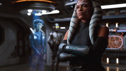 Ahsoka Tano (Rosario Dawson) stands with arms folded, looking at a hologram image of Hera Syndulla (Mary Elizabeth Winstead) in the live-action Star Wars series 'Ahsoka'