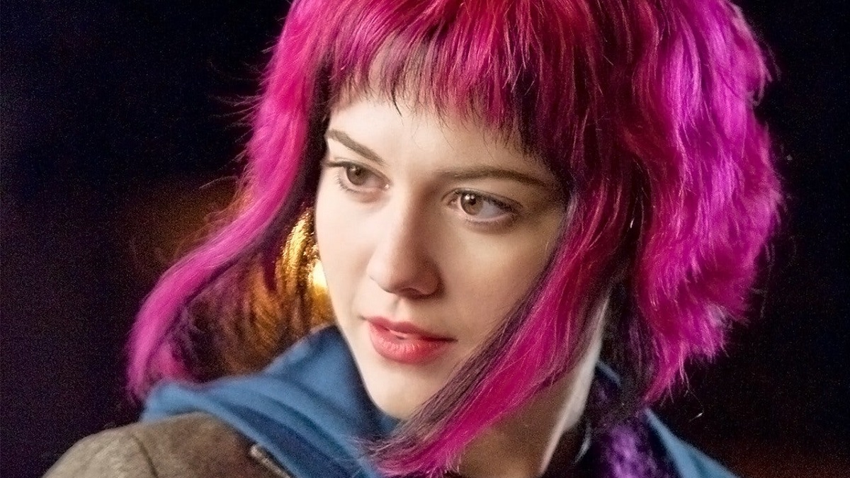 Mary Elizabeth Winstead as Ramona Flowers in a scene from 'Scott Pilgrim vs. the World.' Ramona is a white teenage girl with chin-length, bright pink hair wearing a blue hoodie under a brown jacket.