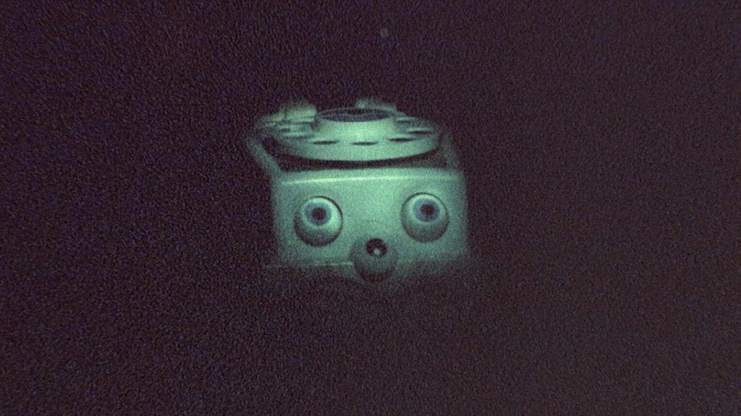 A Fisher-Price Chatter Box toy phone sits in a darkened room in ‘Skinamarink.’ 