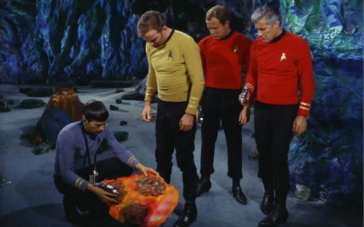 Spock mind melds with a an monster that looks like an orange blob while other members of Starfleet look on in 'Star Trek: The Original Series' 