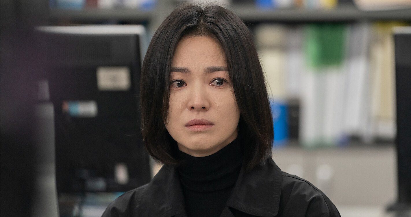 An Asian woman in all black has a stern look on her face