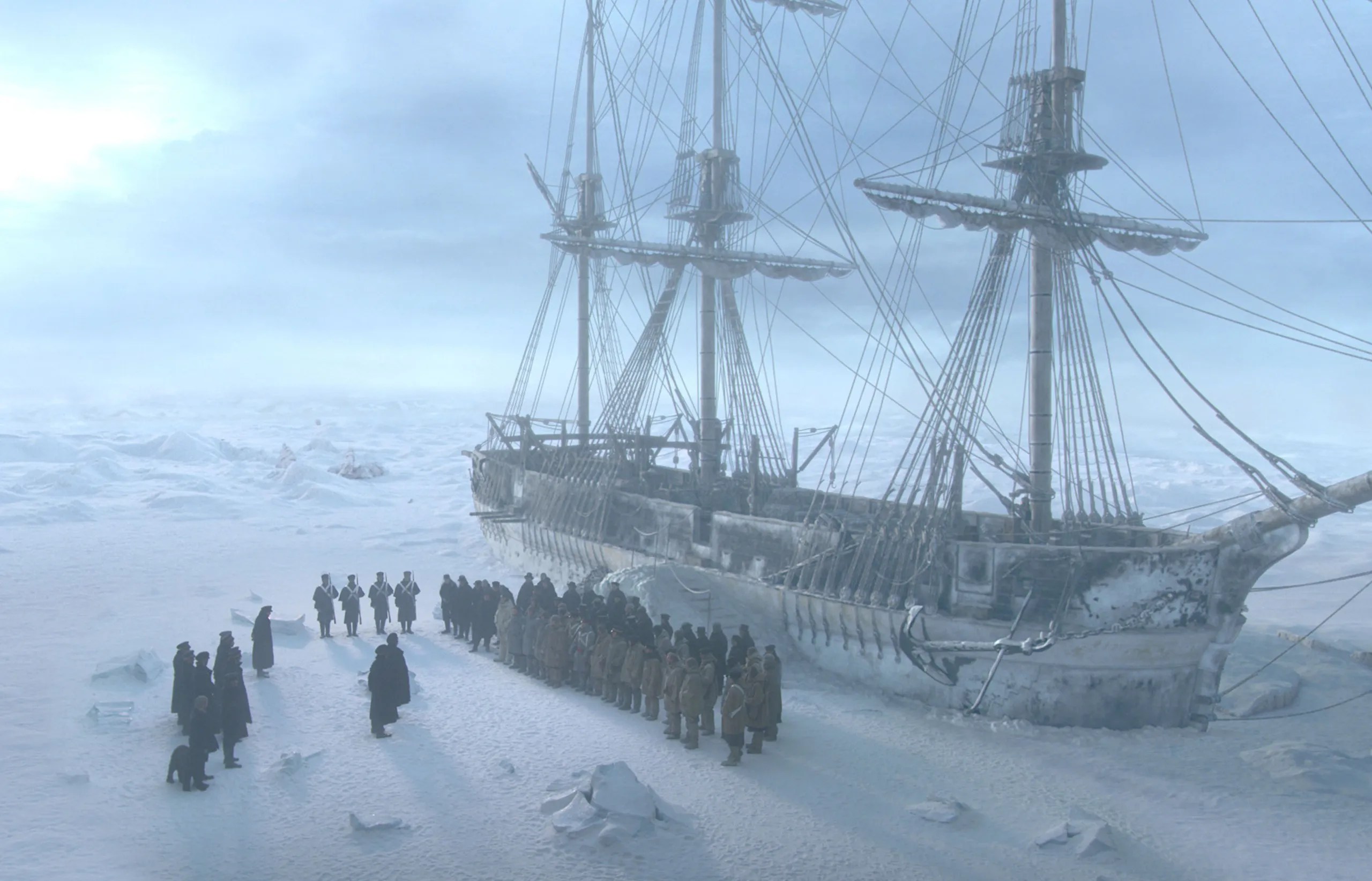 A Royal Navy crew assembles on the Arctic ice beside their ice-lodged explorer ship in 'The Terror.'
