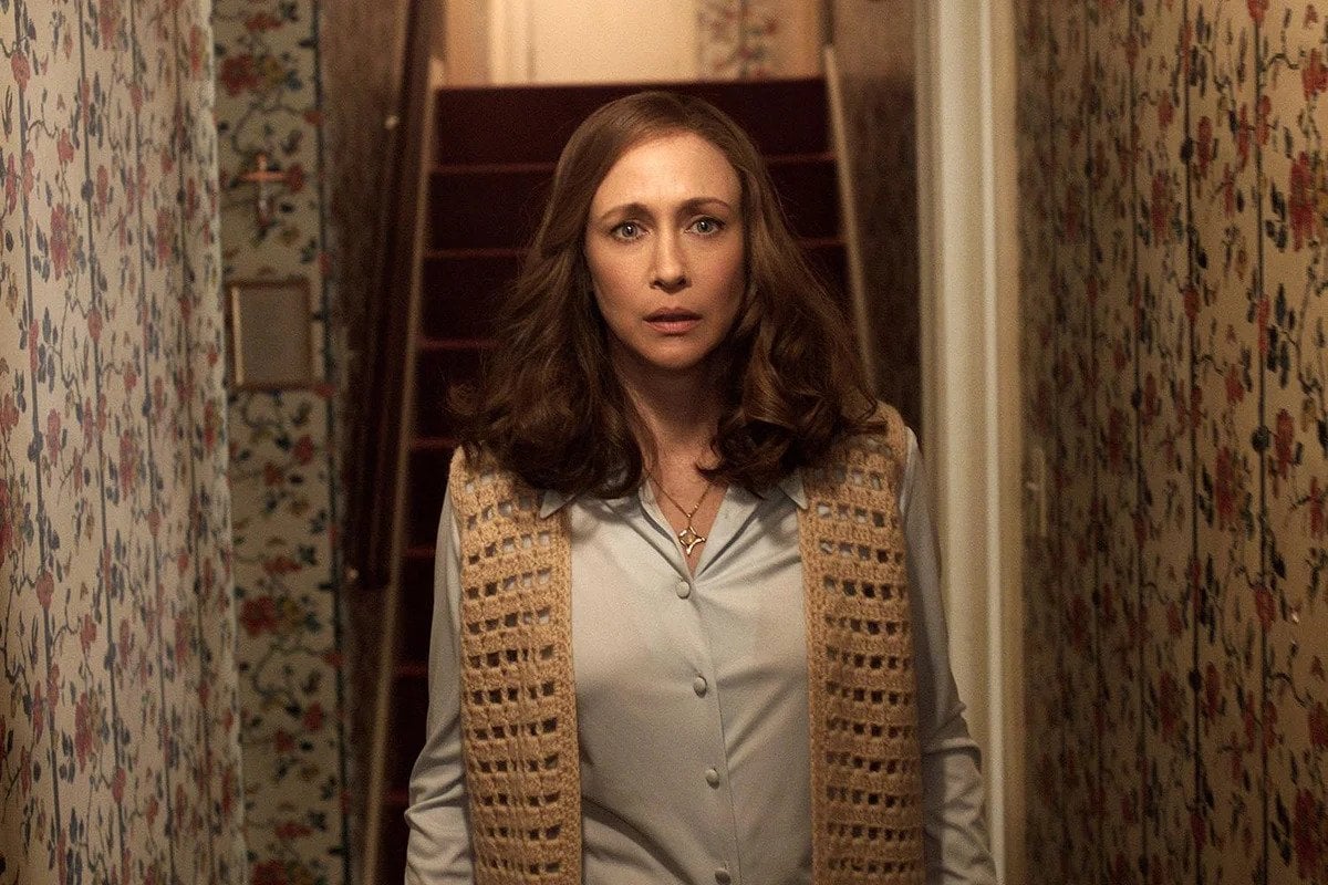 A brown haired white woman looking down a hallway in "The Conjuring 2"