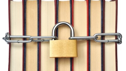 A group of books with a chain around them, with a large padlock in the middle.