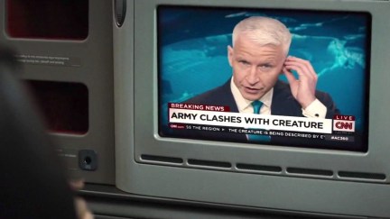 Anderson Cooper on CNN seen on a small TV screen above a chyron reading 