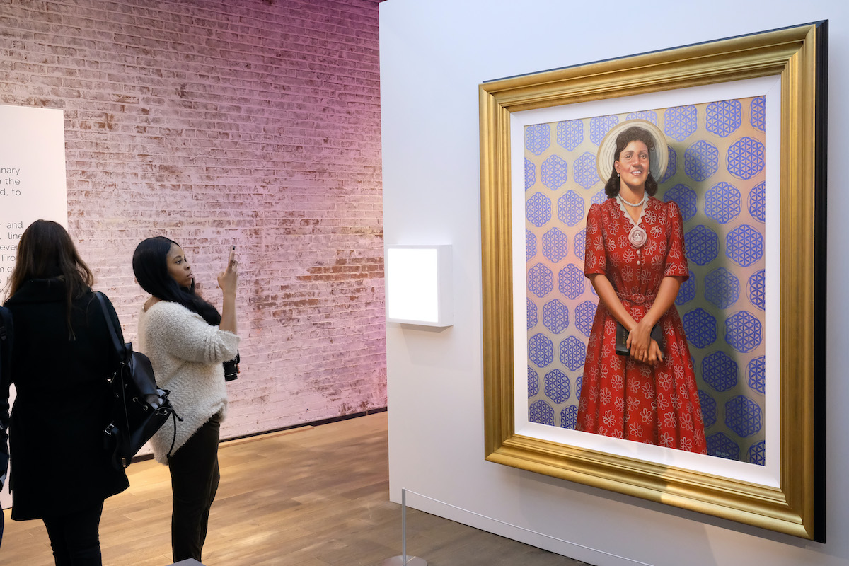 Museum-goers look at a portrait of Henrietta Lacks.