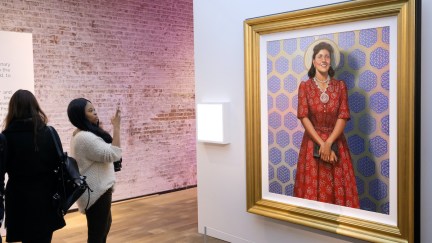 Museum-goers look at a portrait of Henrietta Lacks.
