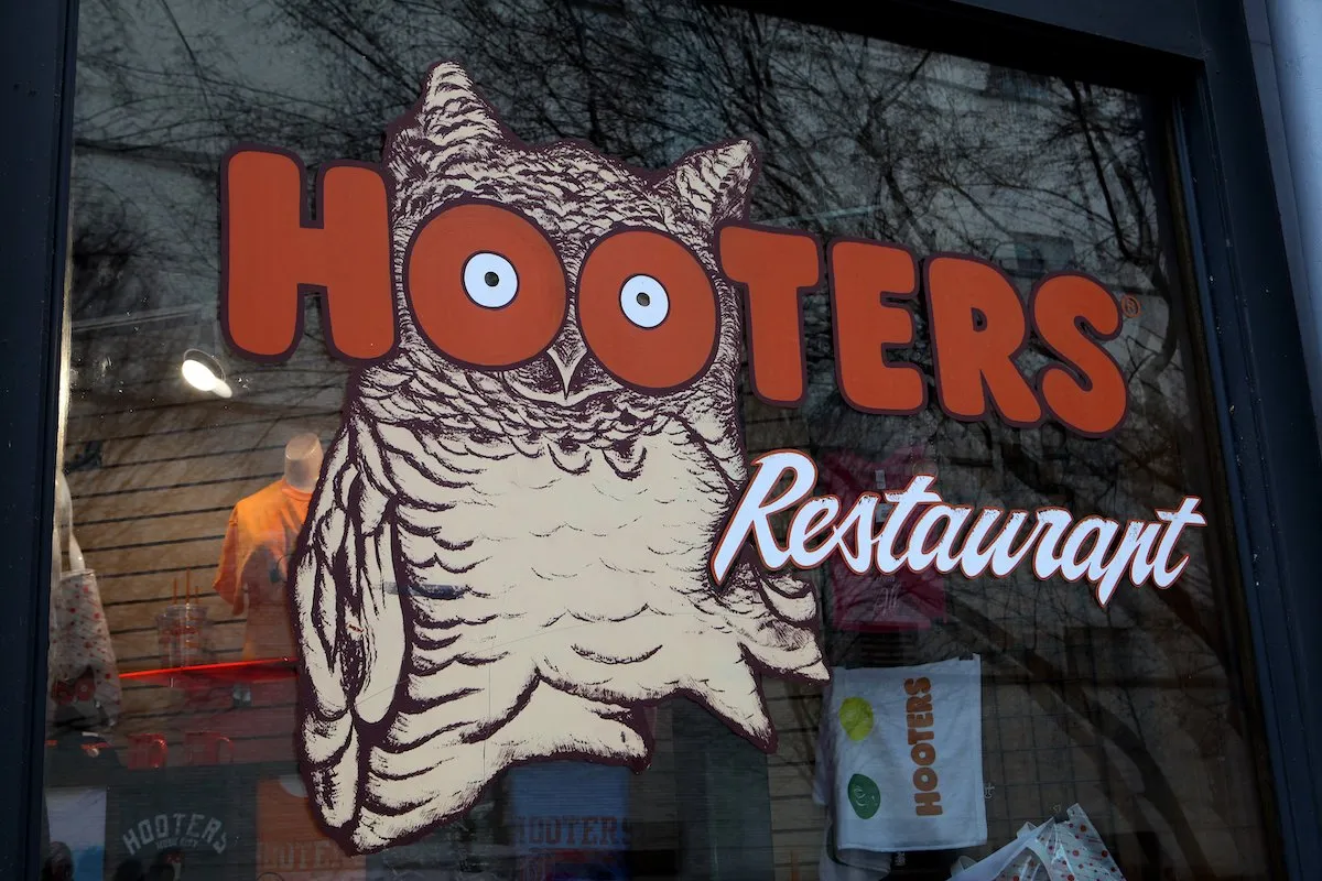 The sign outside a Hooters restaurant featuring its logo of an owl.
