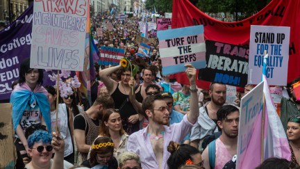 A trans rights rally featuring a large crowd of marching protesters.