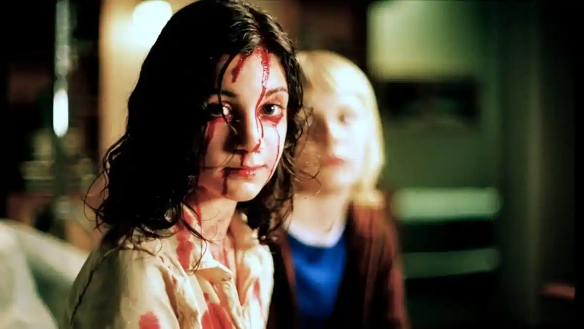 Kåre Hedebrant as Oskar Lina Leandersson as Eli in "Let The Right One In". Eli stares into the camera, covered in blood.