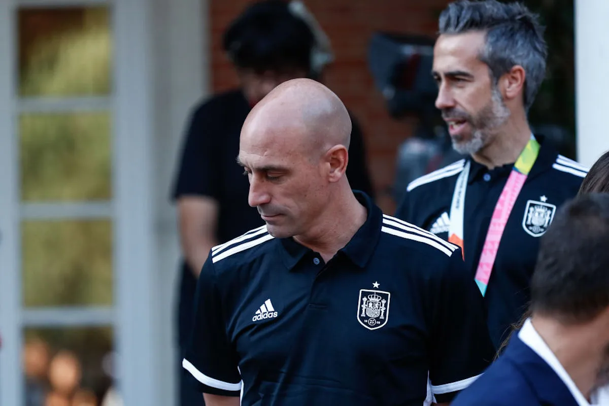 Luis Rubiales, wearing a soccer jersey, walks down some steps at an event.